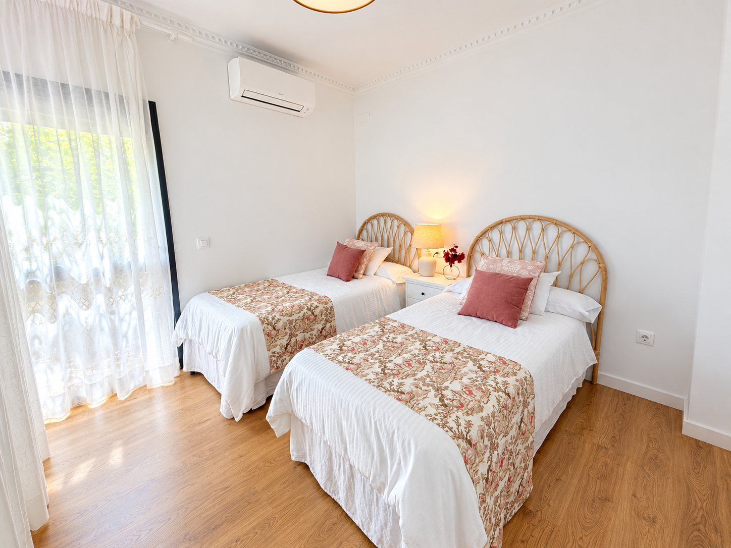 Dormitorio con dos camas individuales y cabeceros de ratán