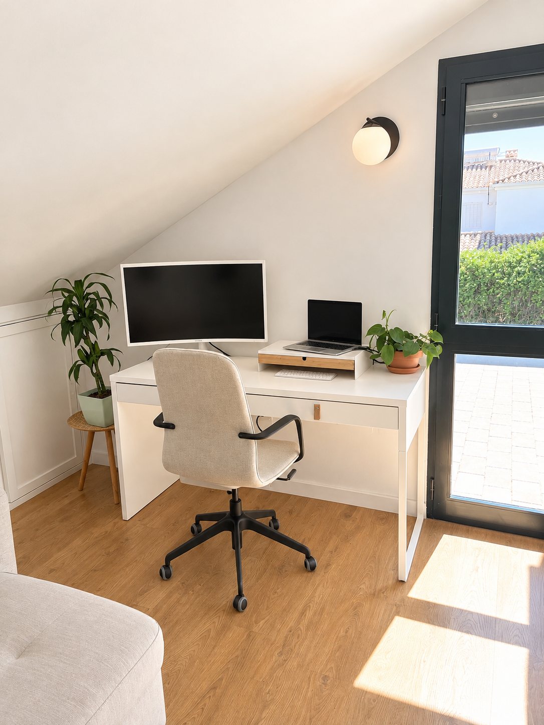 Escritorio blanco con monitor junto a la puerta de la terraza