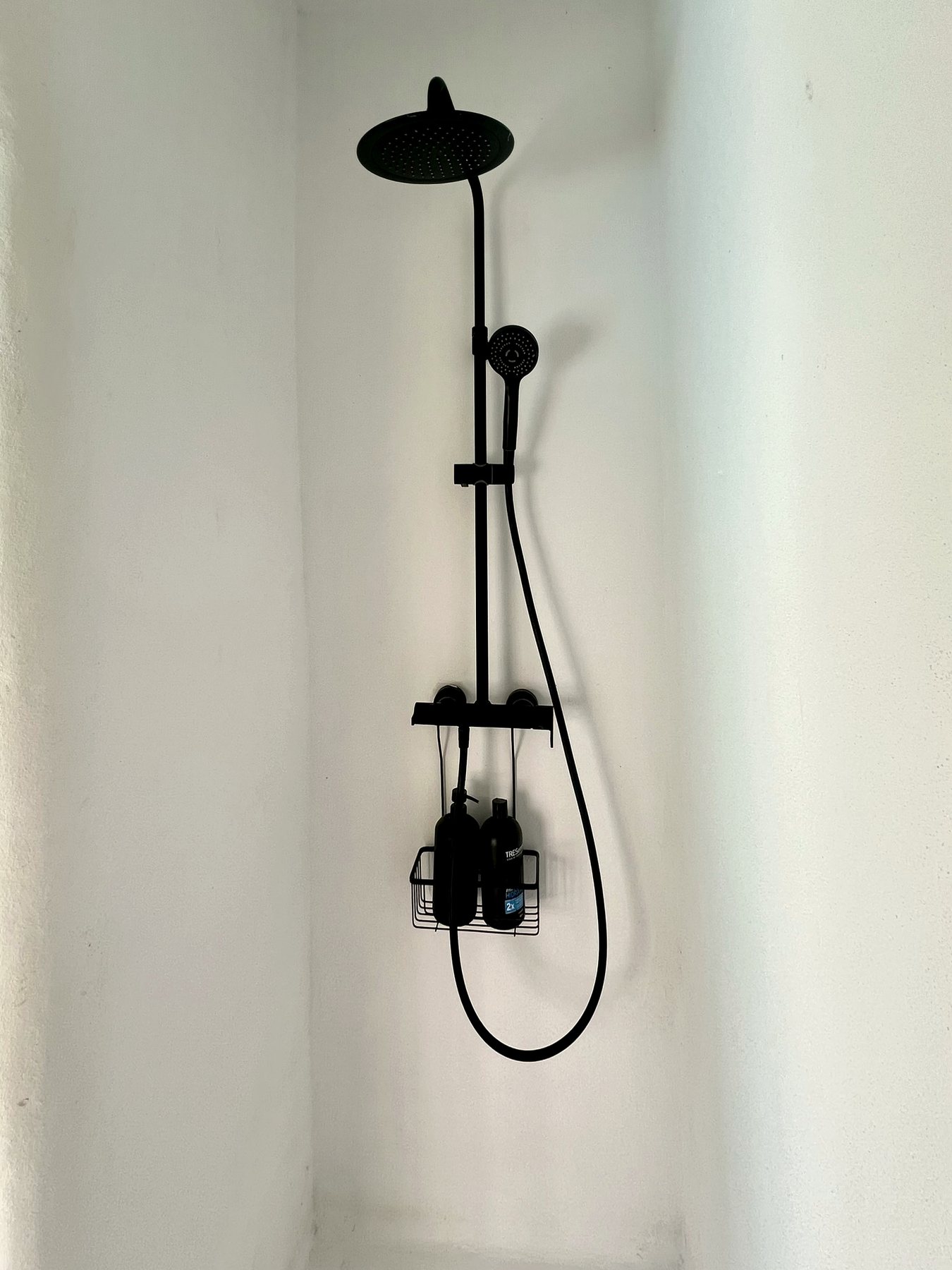 Detalle de la ducha exterior con alcachofa y teléfono de ducha