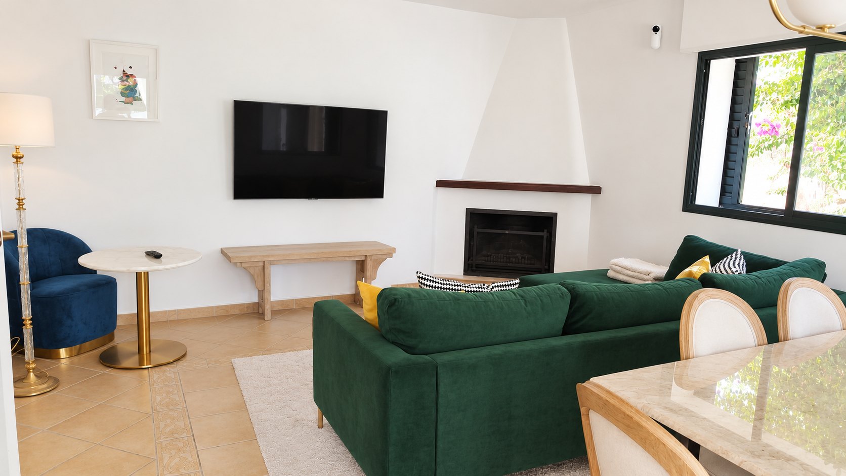 Salón con smart TV, chimenea de esquina y sofá verde