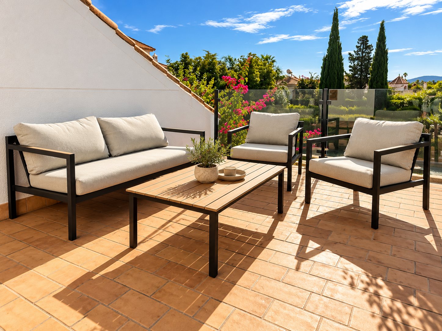 Terraza superior con sofá, sillones y mesa de centro con vistas al jardín